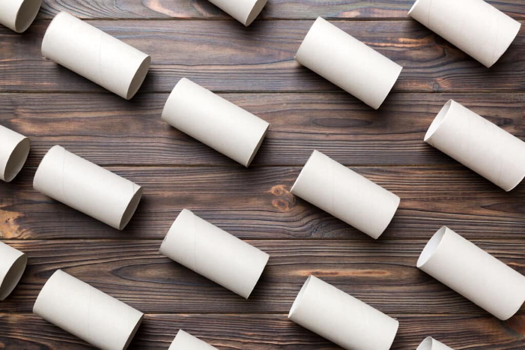 Lint roller refile rolls are arranged in a diagonal pattern on a dark wooden surface.